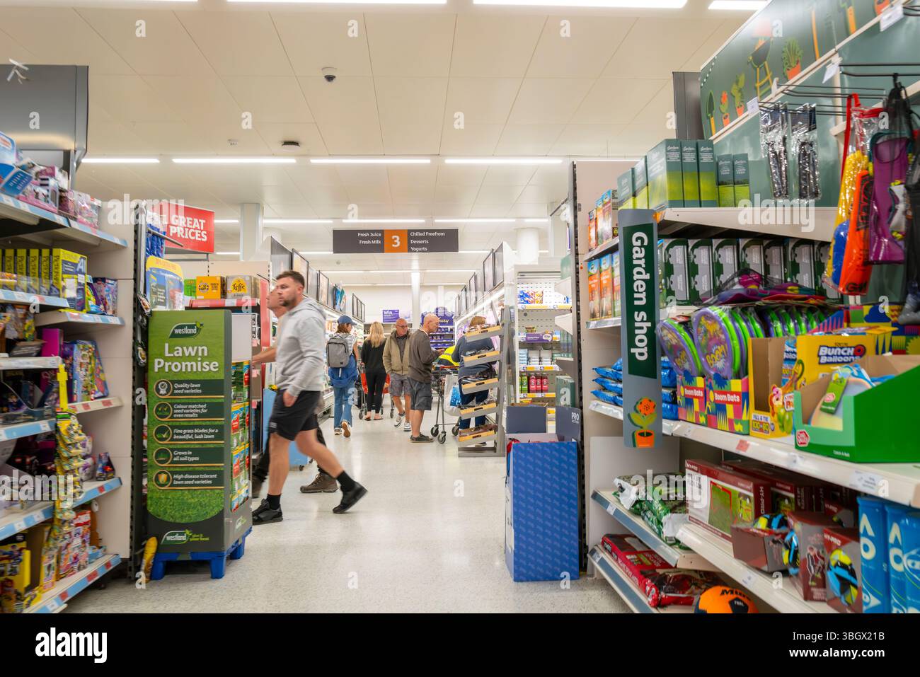 Clienti che camminano lungo un corridoio all'interno di un negozio Sainsburys nel Regno Unito. Foto Stock Clienti che camminano lungo un corridoio all'interno di un negozio Sainsburys nel Regno Unito. Foto Stock