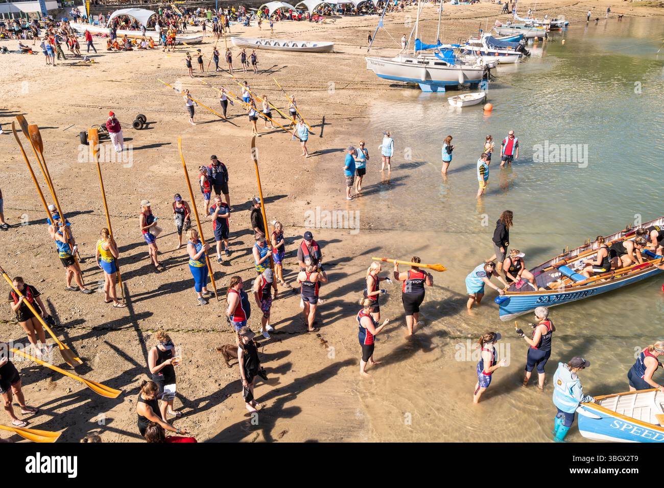 Gli equipaggi dei Pilot Gig che trasportano i loro remi in attesa di salire a bordo dei Pilot Gigs per l'evento femminile Newquay County Championships Cornish Pilot Gig Rowing a Newqu Foto Stock