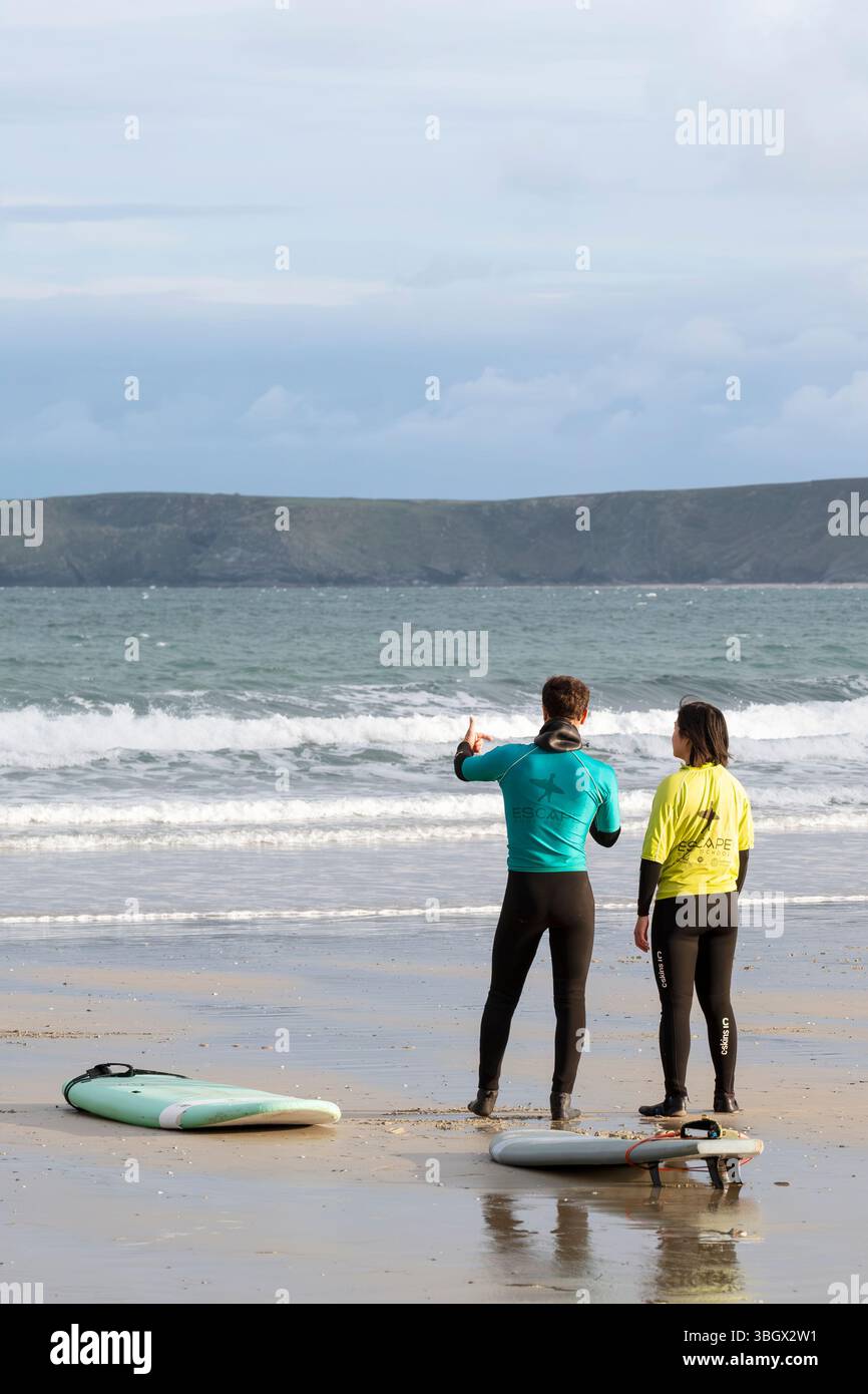 Un istruttore di surf che spiega la tecnica a un principiante a Towan Beach a Newquay in Cornovaglia nel Regno Unito. Foto Stock
