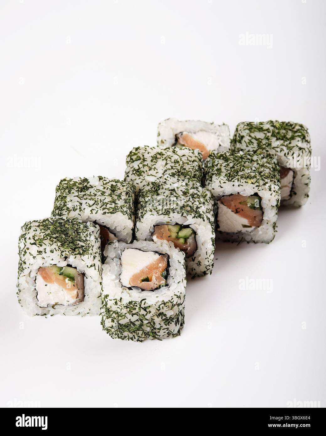 Deliziosi e ben disposti sushi roll ben posizionati su uno sfondo bianco incontaminato Foto Stock