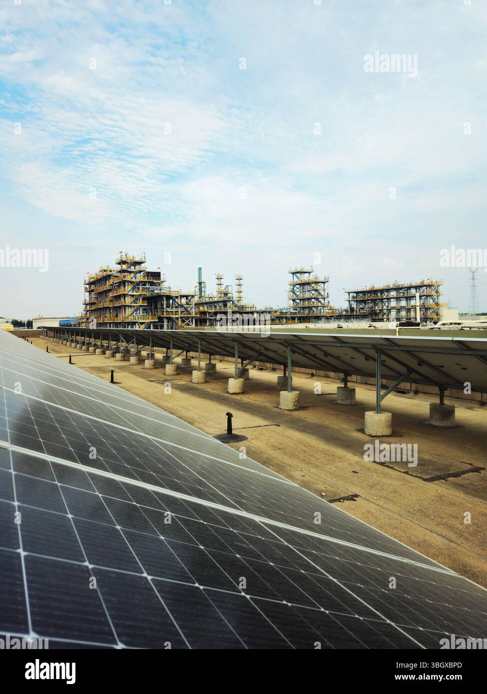Pannelli solari accanto all'impianto petrolchimico - paesaggio di transizione dell'energia industriale Foto Stock