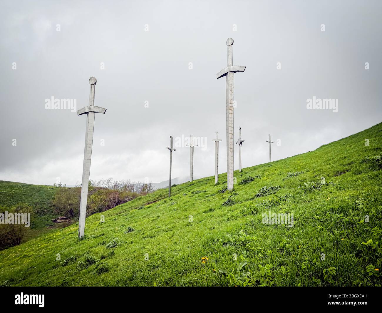 Tbilisi, Georgia, Didgori, enormi sculture di spada metallica sorgono da una collina erbosa sotto un cielo mooso, formando un impressionante monumento pubblico in una Foto Stock