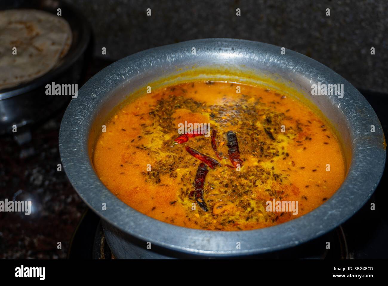 Preparazione tradizionale indiana Arhar dal Tadka con spezie ricche, cucinata in una cucina casalinga per sapori autentici Foto Stock