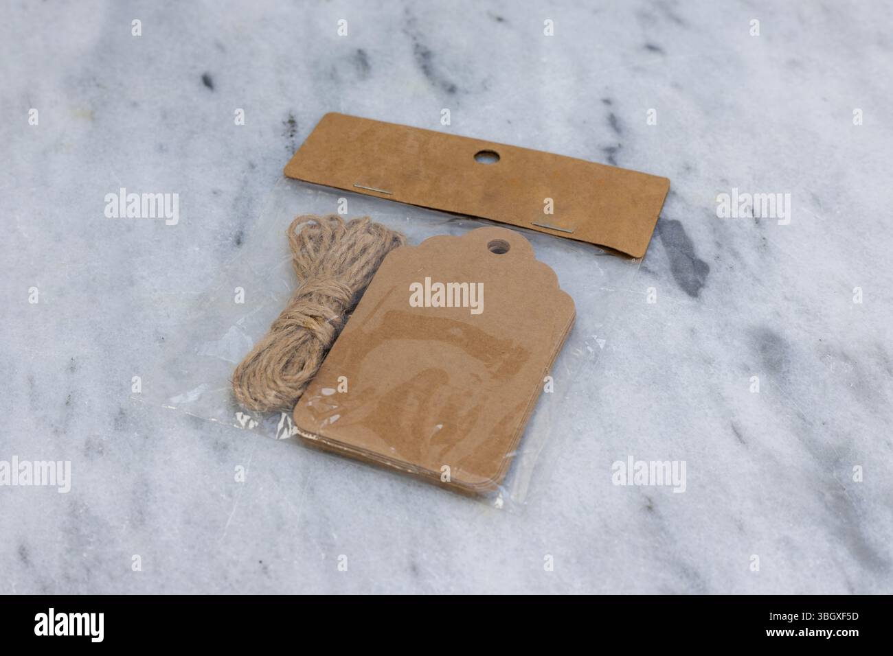 Etichette regalo in carta kraft marrone confezionata con spago di iuta su sfondo di marmo Foto Stock