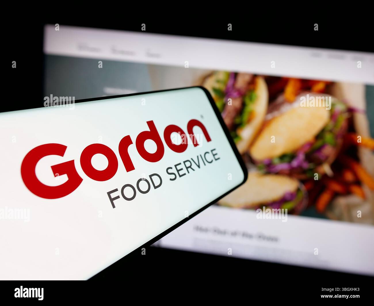 Stoccarda, Germania - 03-10-2025: Smartphone con logo della società statunitense Gordon Food Service Inc. (GFS) sullo schermo davanti al sito Web. Foto Stock
