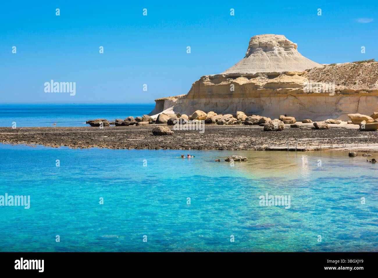 Gozo Malta, vista in estate di una coppia che nuota nell'isolata baia di Xwejni sulla panoramica costa nord di Gozo, Malta. Foto Stock