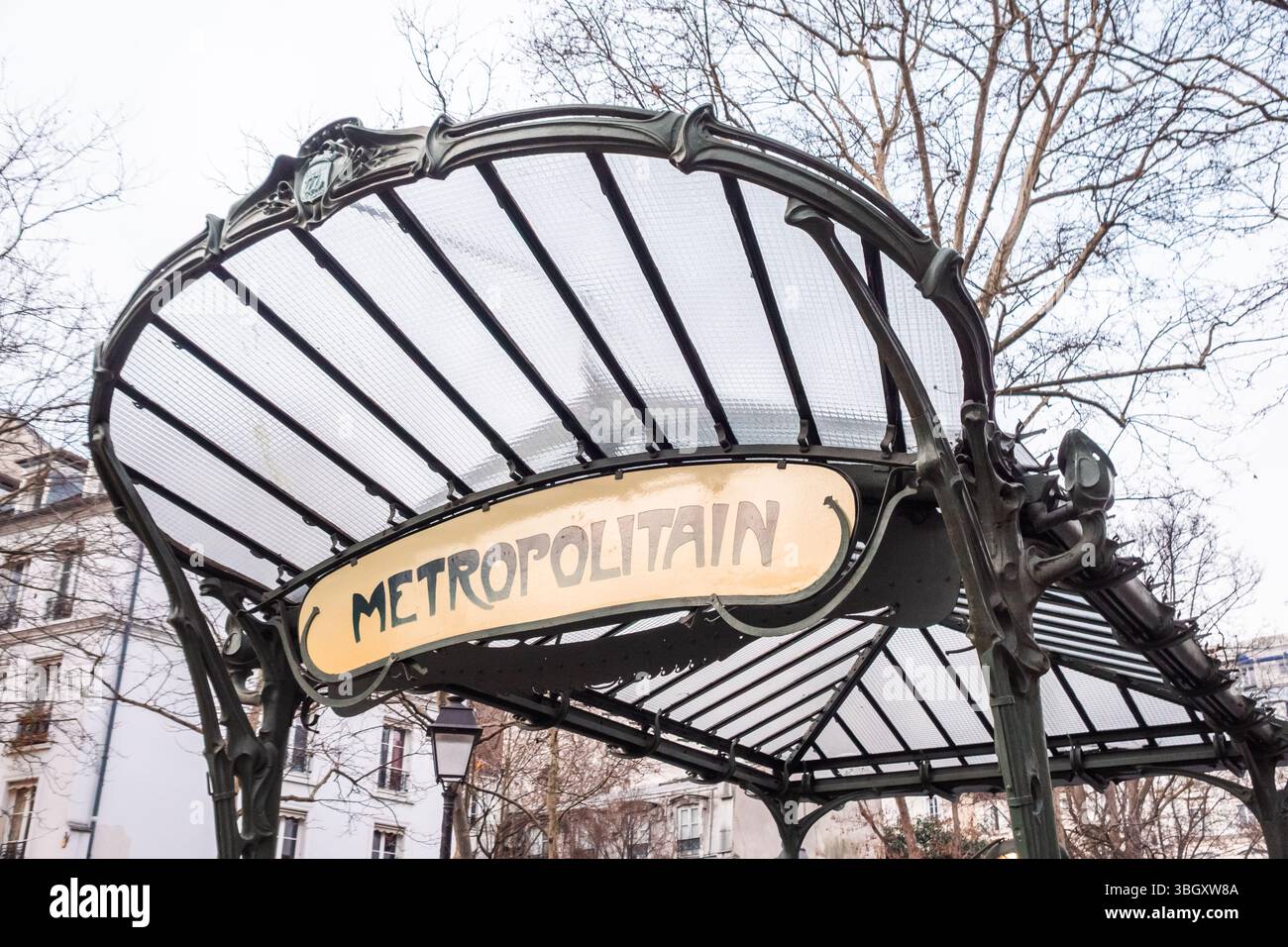 Una vista dall'angolo basso di un iconico baldacchino della metropolitana Art Nouveau 'Metropolitain' a Parigi, progettato con intricati lavori in ferro e un tetto in vetro, nuovamente allestito Foto Stock