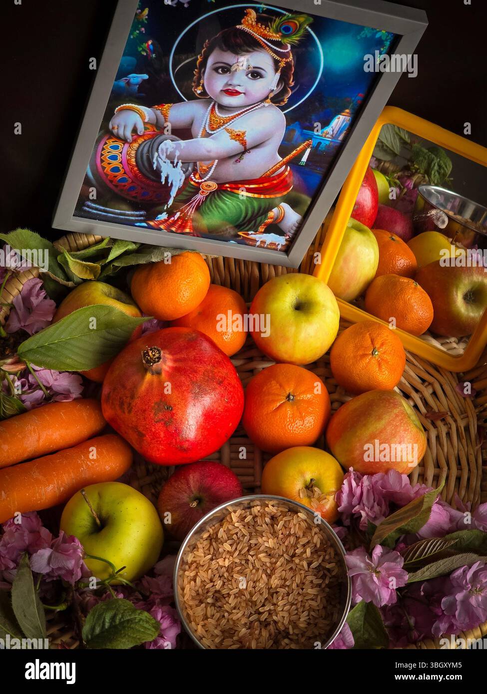 Immagine ravvicinata del Kerala tradizionale Vishu Kani Arrangement con frutta, cereali e foto di Baby Krishna Foto Stock