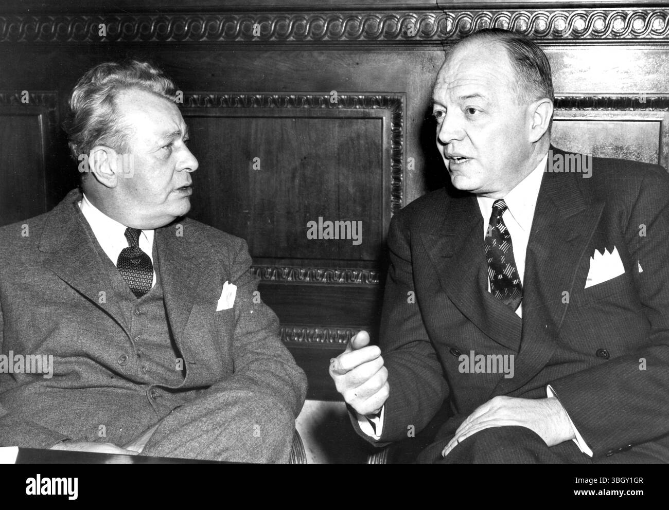 Il Comitato investigativo del Senato ha lanciato una sonda in modo da fermare l'uso di navi statunitensi in eccedenza nel commercio con la Cina, e ha convocato il direttore della sicurezza reciproca Harold Stassen (a destra) in una sessione a porte chiuse per discutere il problema. A parlare con Stassen c'e' il senatore Everett M.Dirksen dell'Illinois, poco prima dell'udienza. 18 marzo 1953 Foto Stock