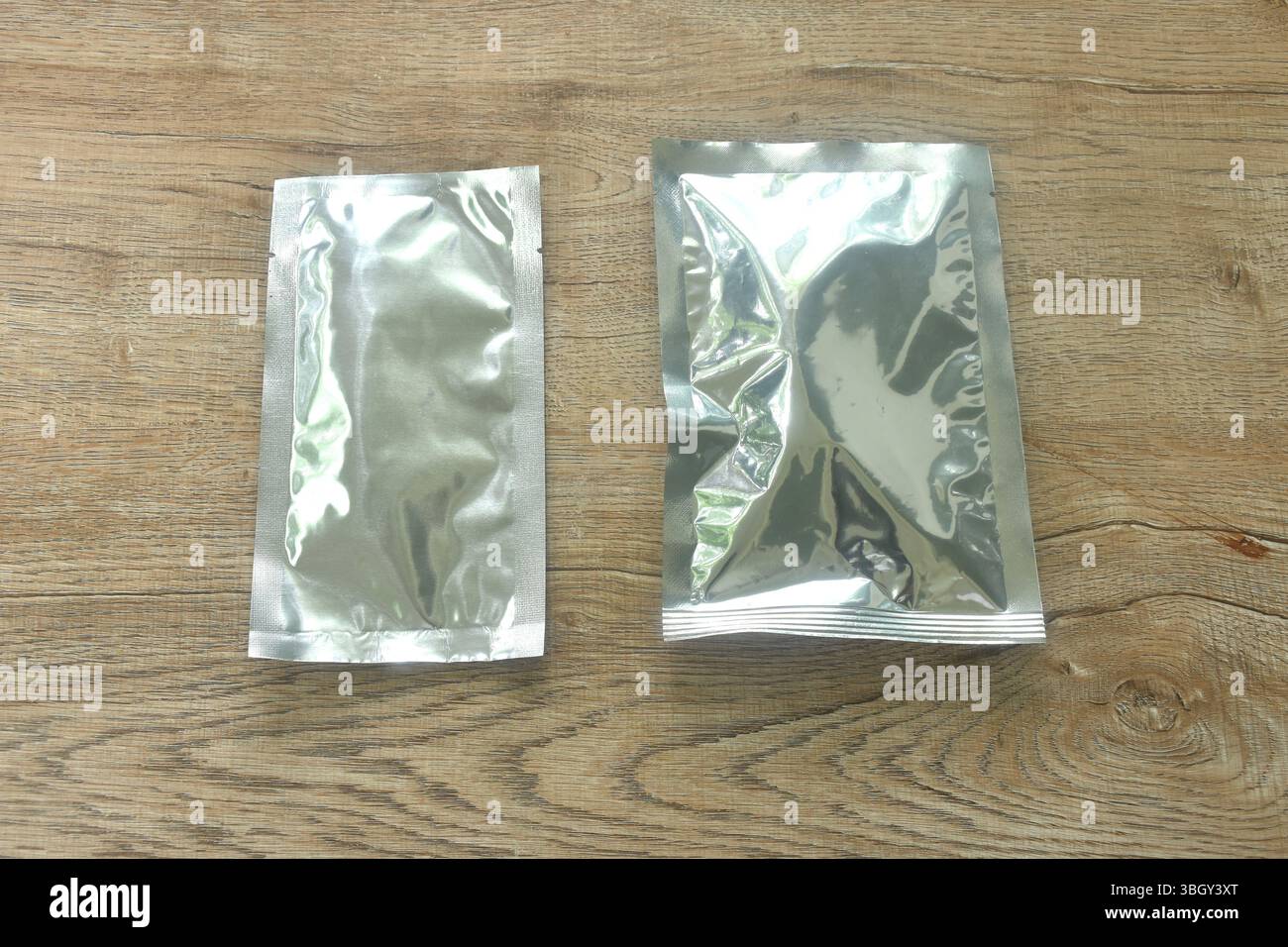 pacchetto snack con mock-up in alluminio, da ordinare sul tavolo Foto Stock