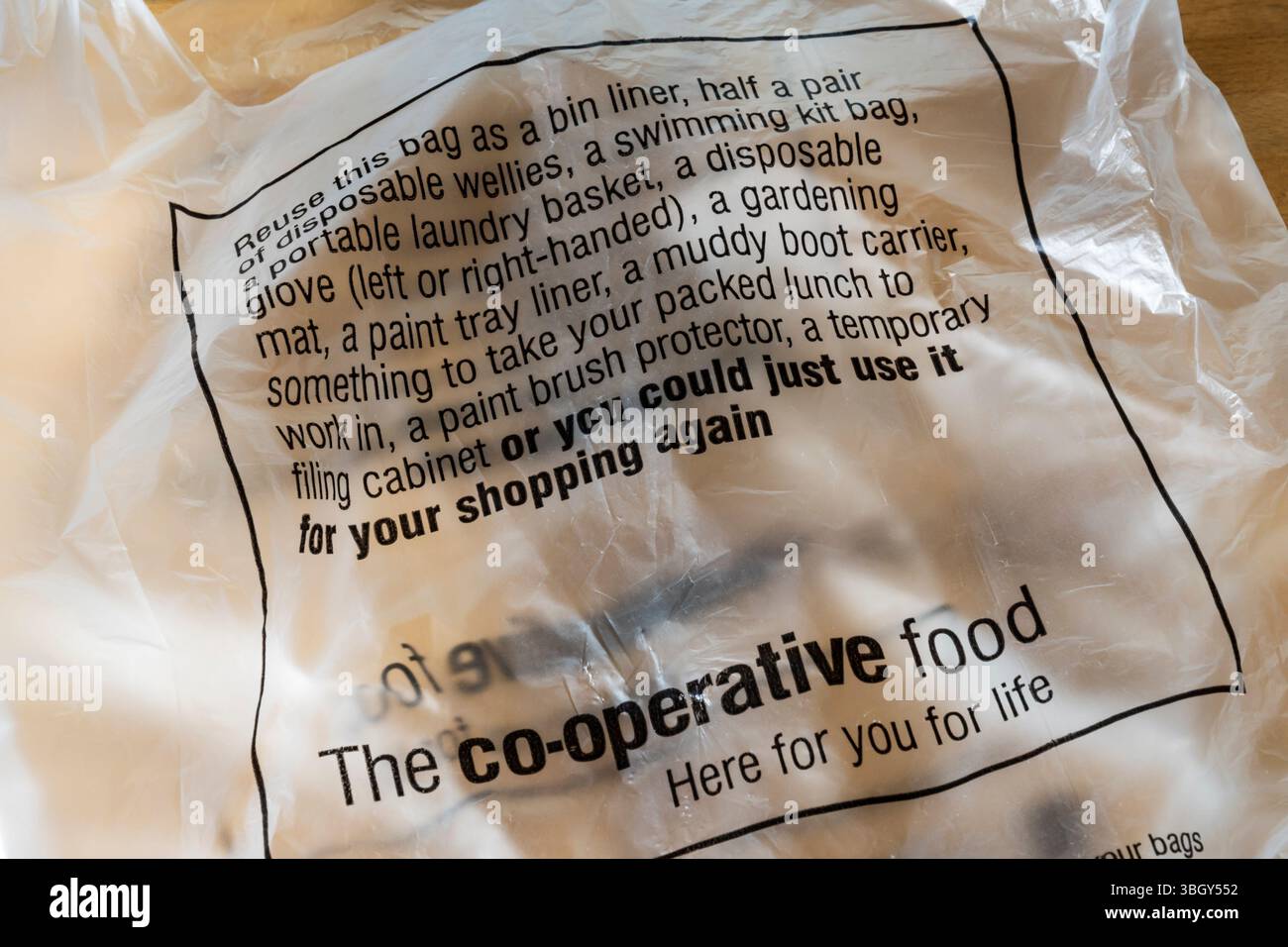 Sacchetto di plastica Co-Op stampato con suggerimenti su come riutilizzarlo. Foto Stock