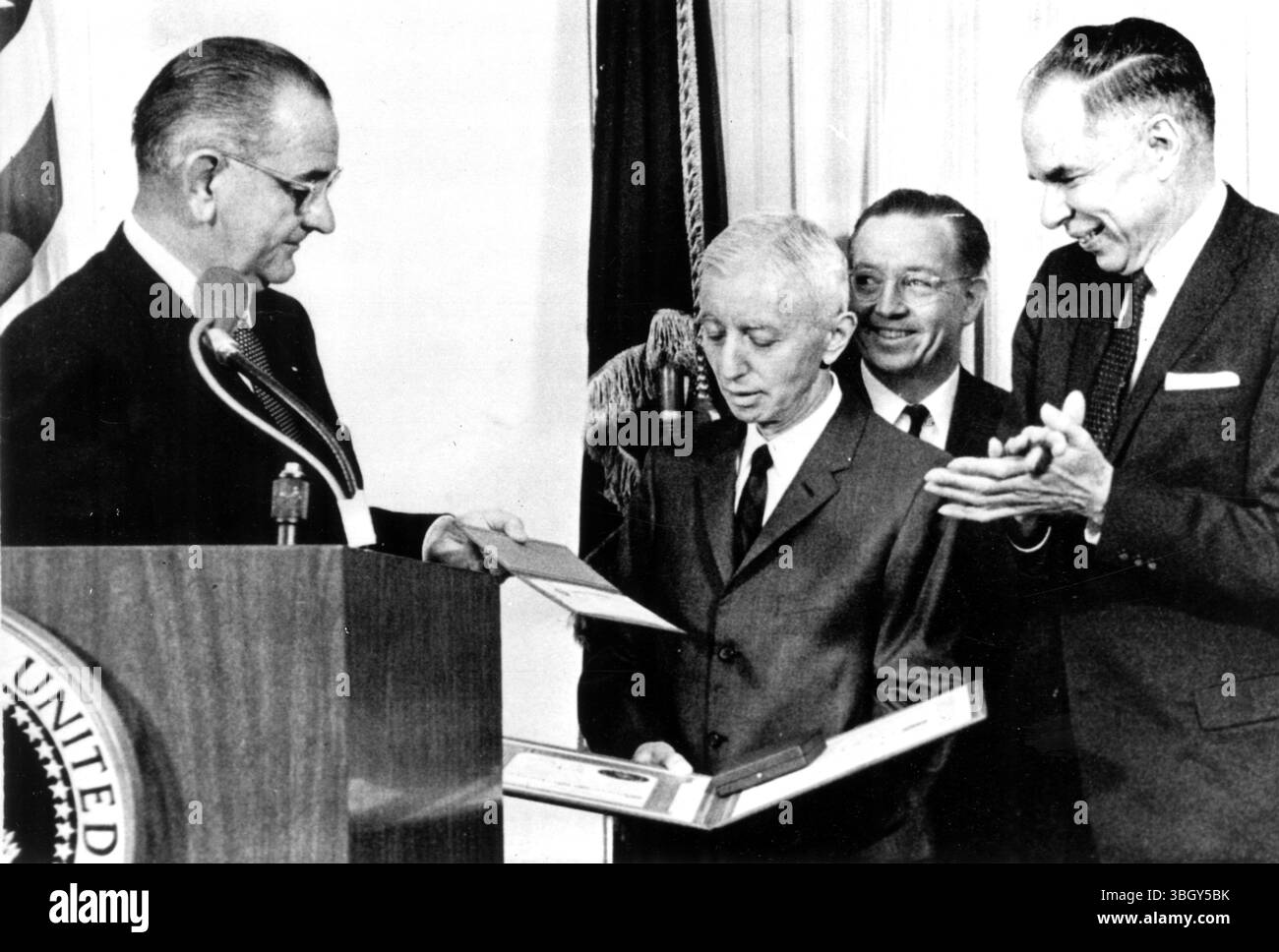 Il presidente Lyndon B. Johnson consegna il premio Enrico fermi 1964 al vice ammiraglio Hyman G Rickover (centro) durante una cerimonia alla Casa Bianca. Glenn Seaborg (a destra), presidente della Commissione per l'energia atomica (AEC), e un Commissario AEC James T Ramey (dietro Rickover), guardate. 14 gennaio 1965 Foto Stock
