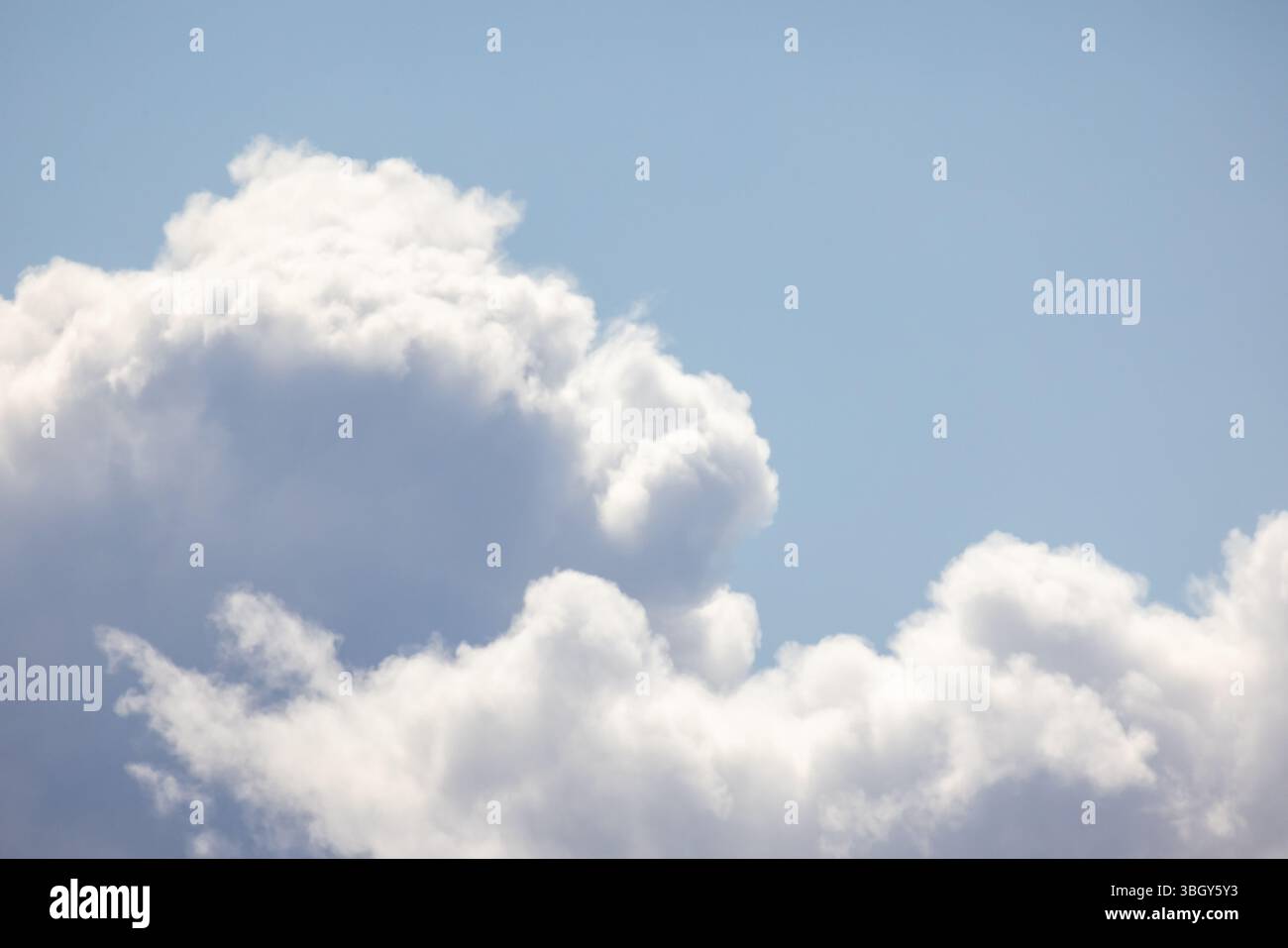 Soffici nuvole bianche fluttuano pacificamente contro un cielo blu vibrante catturato in una giornata di sole, ispirando emozioni tranquille e serene. Sfondo fotografico naturale Foto Stock