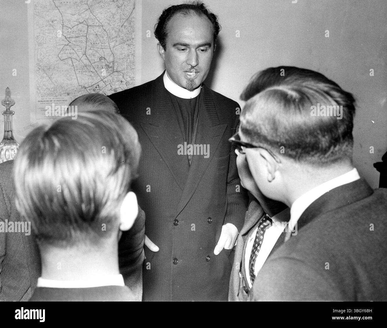 Prende il posto del prete greco deportato. Padre James Pililis si converte con i membri della stampa presso la All Sts Greek Orthodox Church di Camden Town, Londra. 12 giugno 1956 Foto Stock