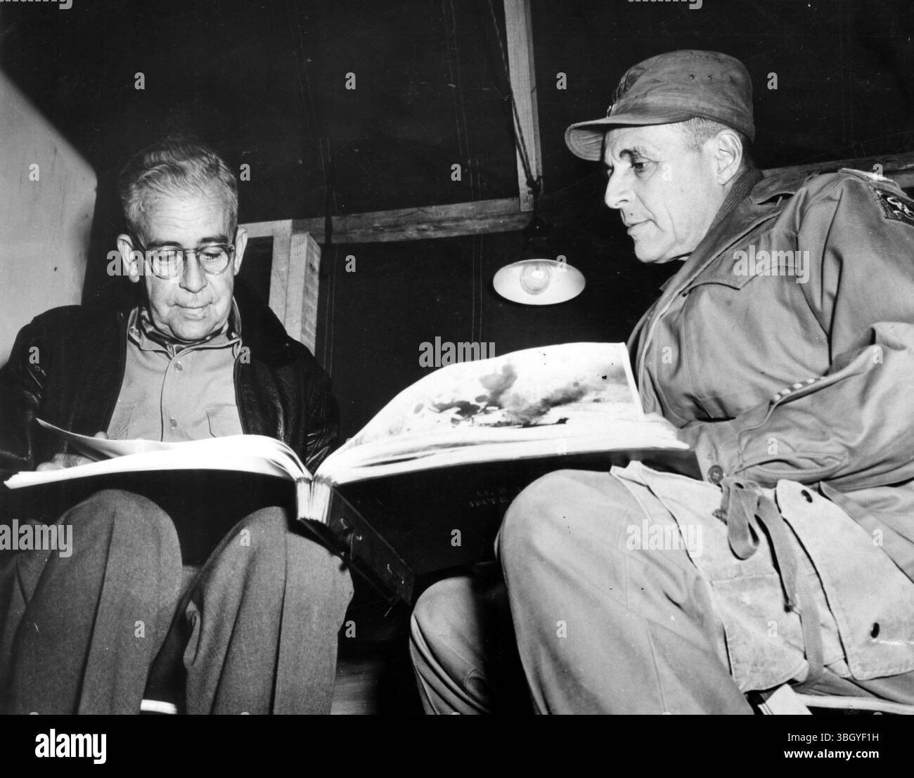 L'ammiraglio C Turner Joy (a sinistra) sfoglia un album fotografico della guerra coreana con il comandante supremo delle forze delle Nazioni Unite, il generale Matthew B Ridgway, durante la visita del comandante al campo base in Corea. 16 novembre 1951 Foto Stock