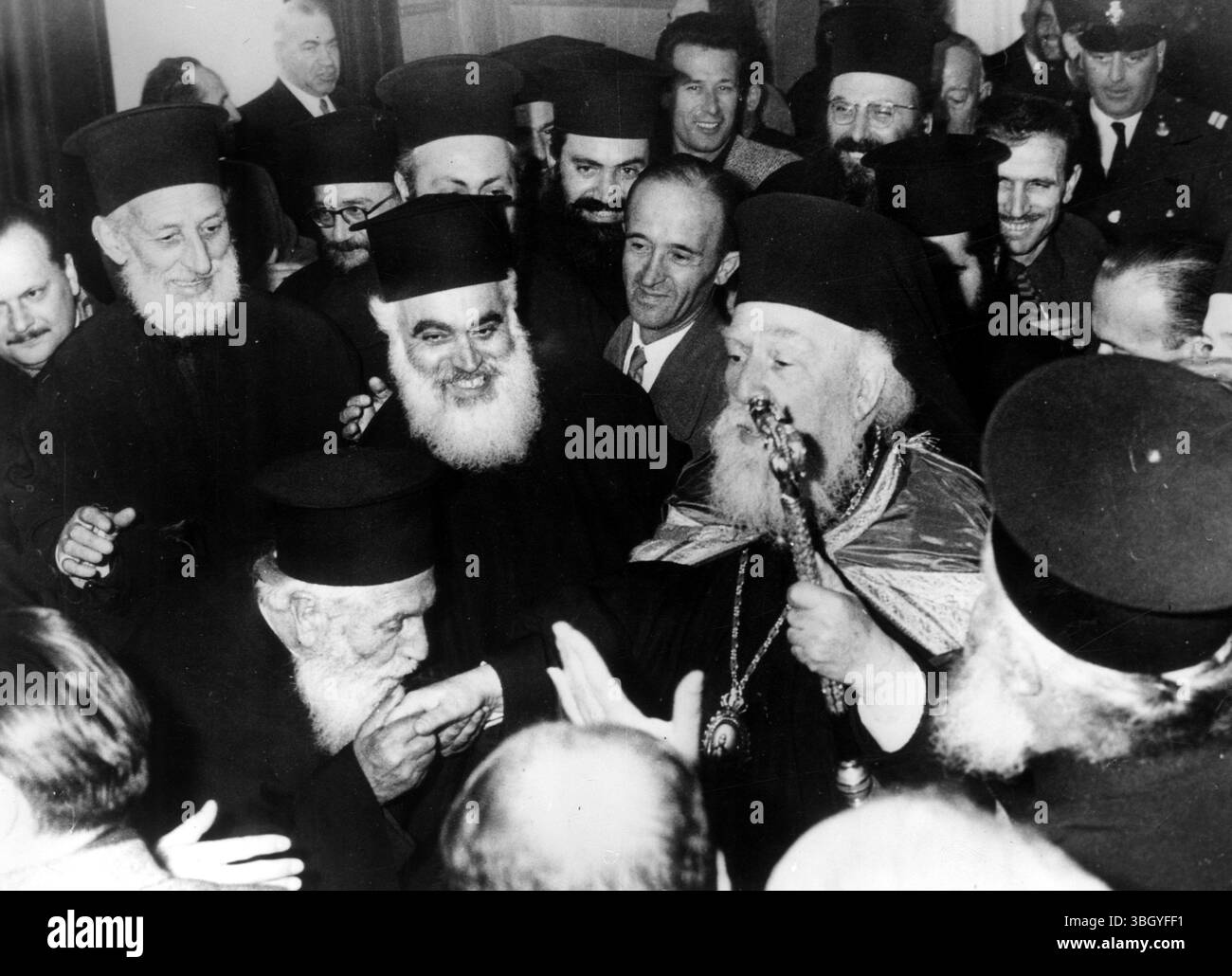 Nuovo primate di Grecia. - Il vescovo di 67 anni Iakovos, metropolita di Attica, e Megaris, che porta il suo staff, è circondato da persone benestanti all'interno della cattedrale di Atene ieri, dopo essere stato eletto arcivescovo di Atene e di tutta la Grecia, in successione all'arcivescovo Teoclito, morto la settimana scorsa. L'elezione, da parte dei vescovi della Chiesa di Grecia, ebbe luogo in un conclave segreto, e durò quasi 6 ore. - La sua elezione era stata contrastata dalla stampa e da alcune organizzazioni religiose, e sono state prese precauzioni speciali fuori dalla cattedrale per evitare incidenti. Qualche studente in Th Foto Stock