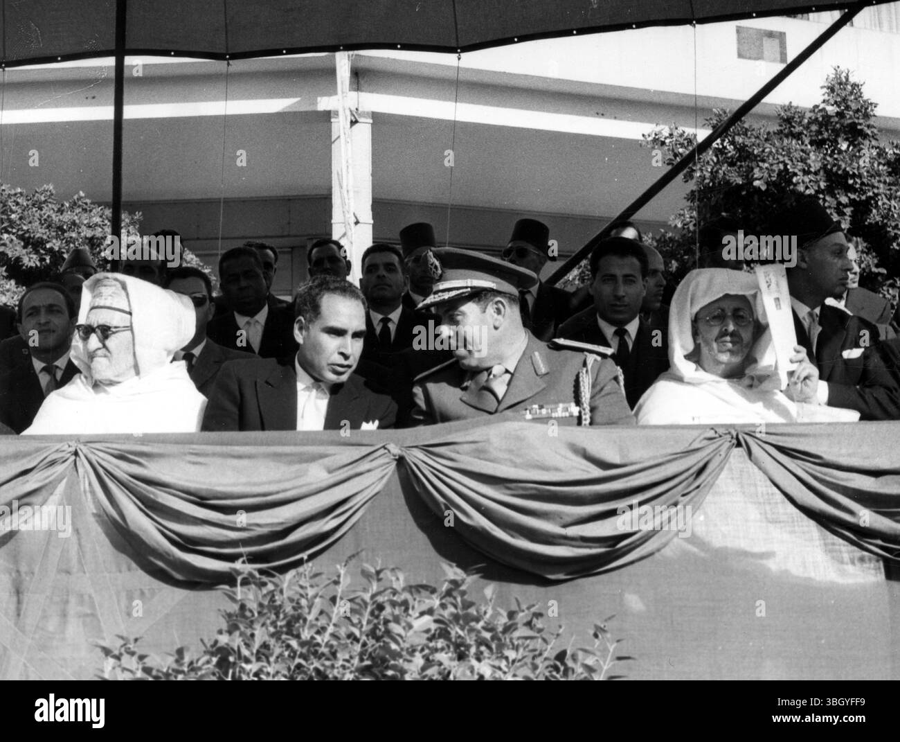 Il Premier marocchino e l'UAR General partecipano alla sfilata. Il primo ministro marocchino, Abdallah Ibrahim (lasciato in tuta oscura e senza odio), parlando con il generale Saad Eddie Salem della Repubblica Araba Unita (in uniforme), quando assistettero a una delle più grandi manifestazioni di forza del Marocco da quando il paese acquisì la sua indipendenza. Oltre 16.000 soldati e nuove attrezzature corazzate, compresi pezzi da campo, come carri armati e camion, parteciparono alla parata. 17 novembre 1959 Foto Stock