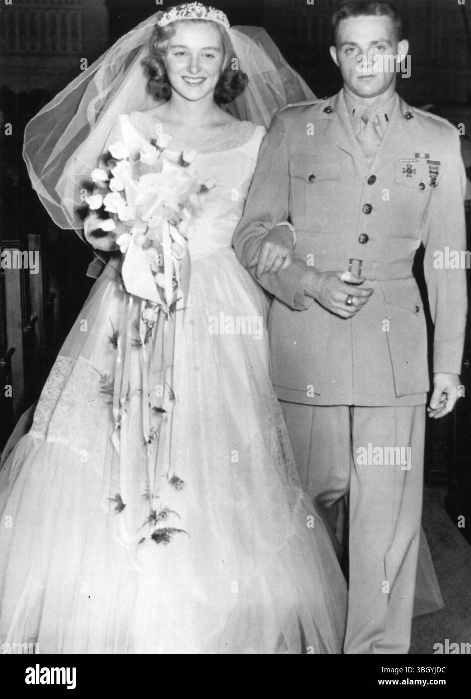 Sposi nuotatori. Shirley May France, 21 anni, che ha provato due volte a nuotare nel canale della Manica, scende lungo la navata con il tenente Douglas E. Smith dopo che è diventata Mrs Smith in una cerimonia al Baptists Temple. 27 aprile 1954 Foto Stock