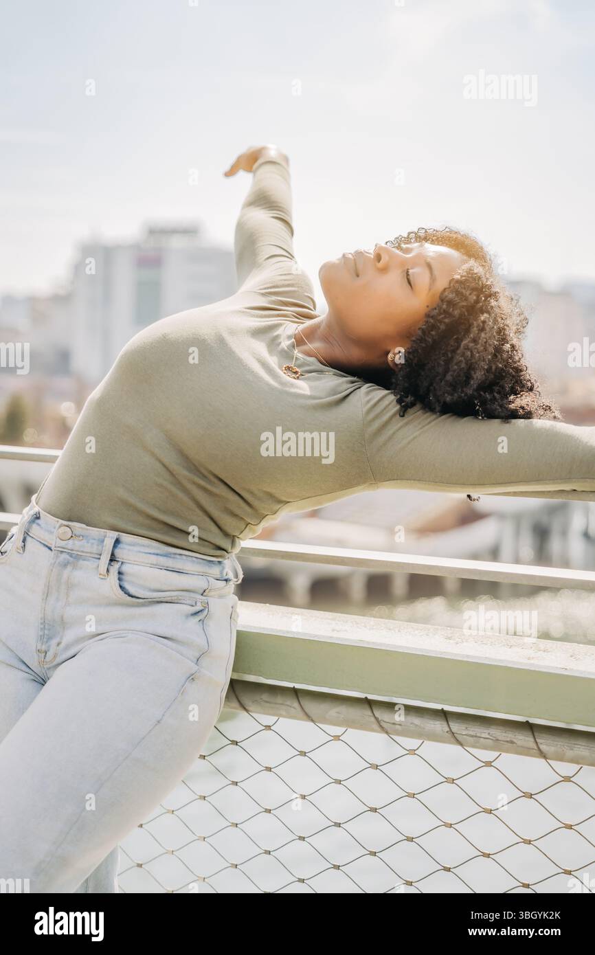 La ballerina si appoggia con grazia alla schiena con gli occhi chiusi e le braccia tese Foto Stock