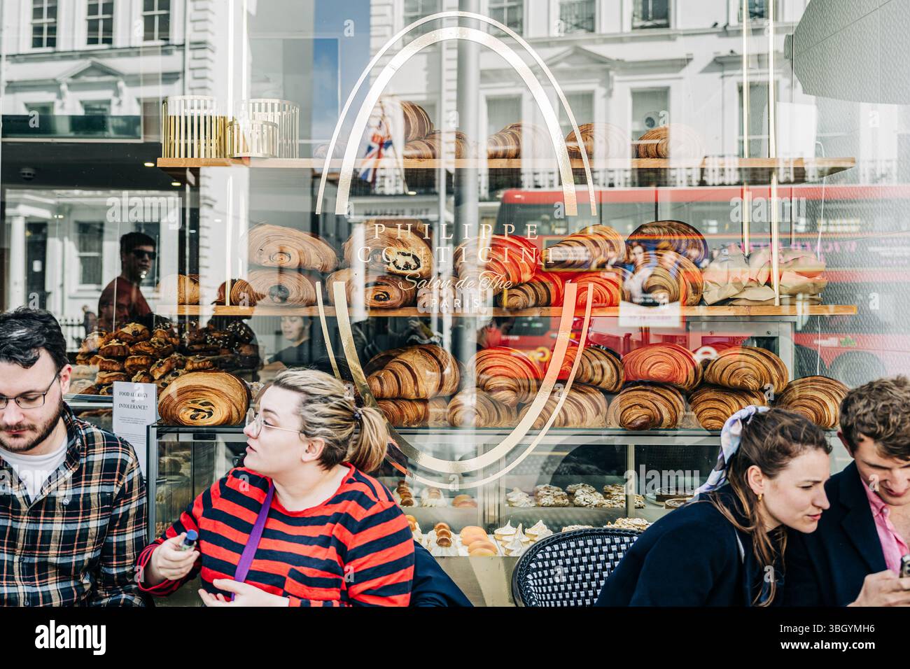 Negozio di prodotti da forno con vetrina di pasticceria e persone sedute all'esterno Foto Stock