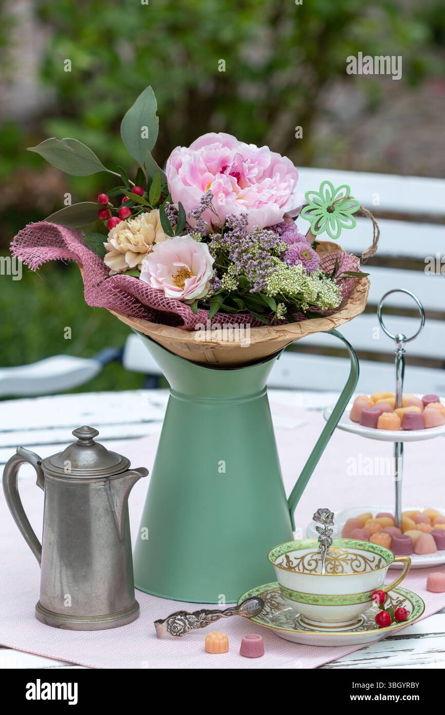 disposizione dei tavoli con bouquet, tazza in porcellana, barattolo da caffè e caramelle su un banco per torte Foto Stock