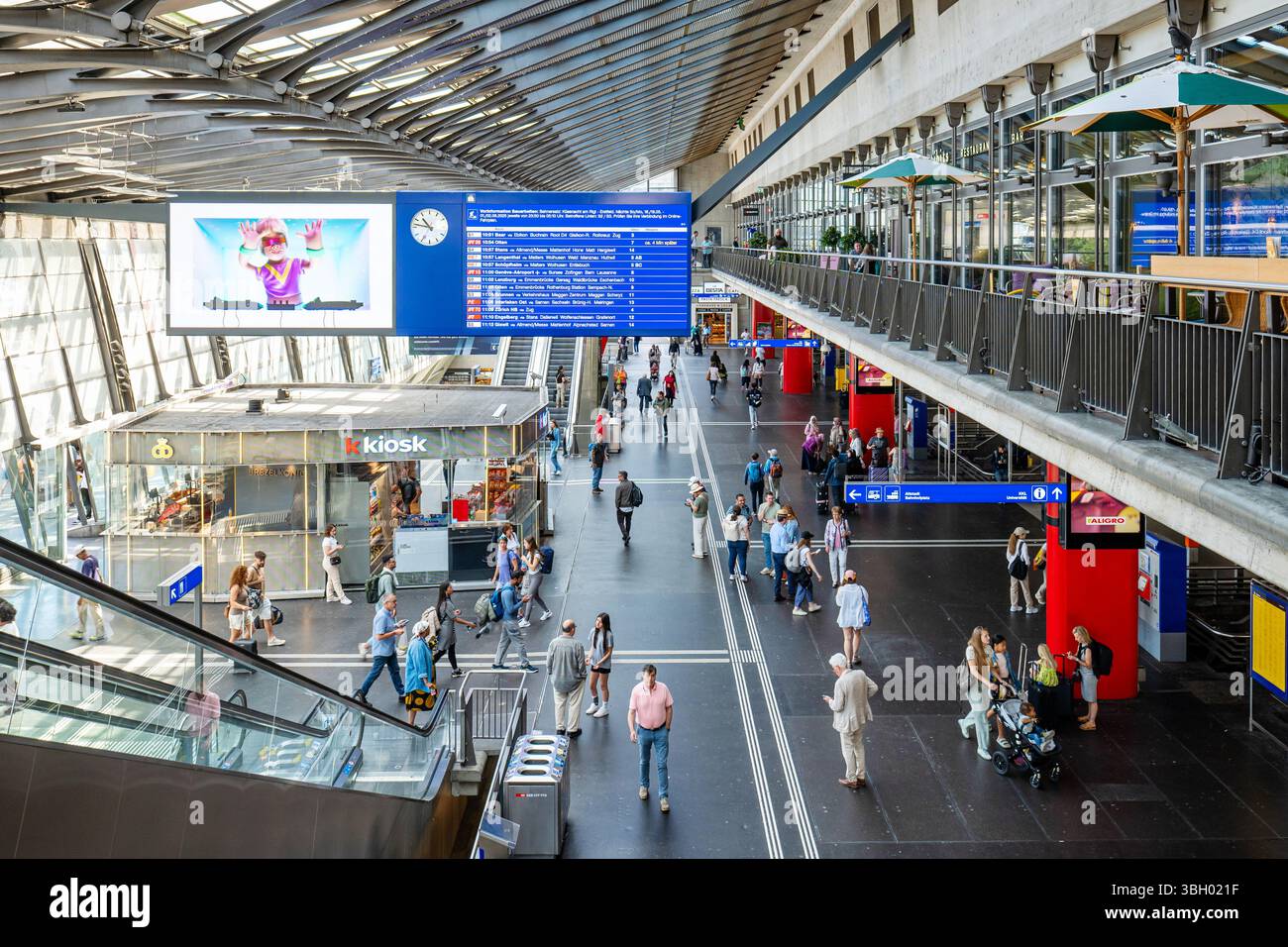 30-05-2025 Lucerna, Svizzera. Vista interna della hall della stazione ferroviaria principale. Soffitto in vetro, luce naturale, vista grandangolare dall'alto, persone in viaggio Foto Stock