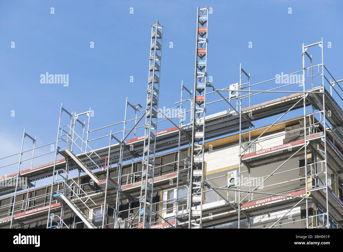Immagine simbolica, costruzione residenziale, nuovo edificio, edificio ad angolo con ponteggi estesi, industria edile, commercio, cielo limpido, Baden-Wue Foto Stock