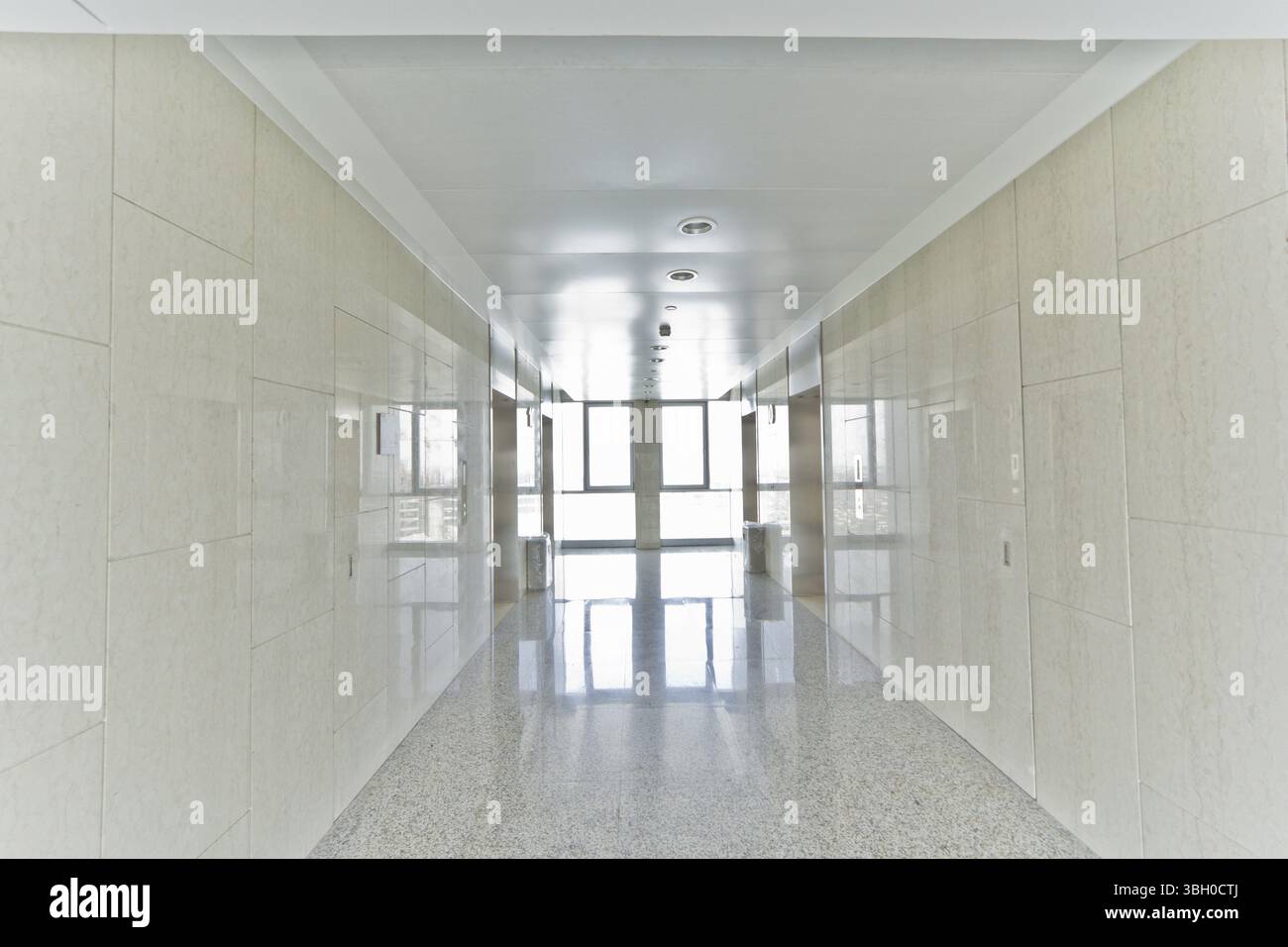 Un ufficio vuoto corridoio con una luce alla fine del corridoio Foto Stock