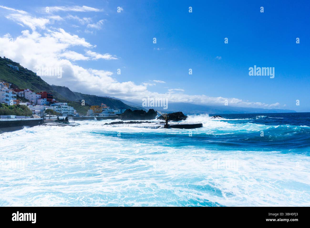 Rough Sea copre le piscine rocciose naturali di El Pris nel nord di Tenerife, Una scena costiera selvaggia con onde spumeggianti e un robusto litorale vulcanico nel Foto Stock