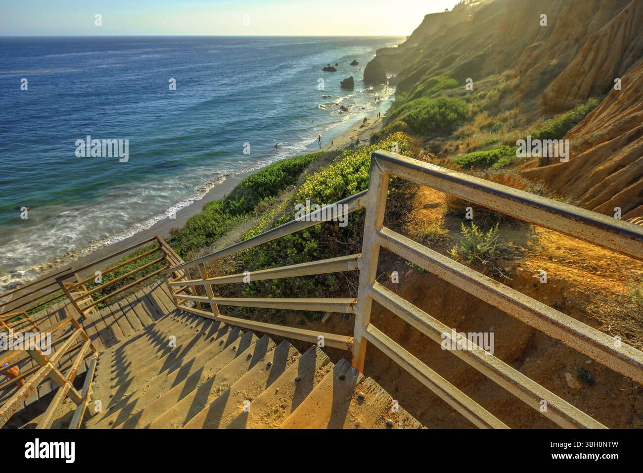Scenic scalinata in legno che conduce giù per El Matador spiaggia di Stato alla luce del sole. Costa del Pacifico, California, Stati Uniti. I pilastri e le formazioni rocciose di mo Foto Stock