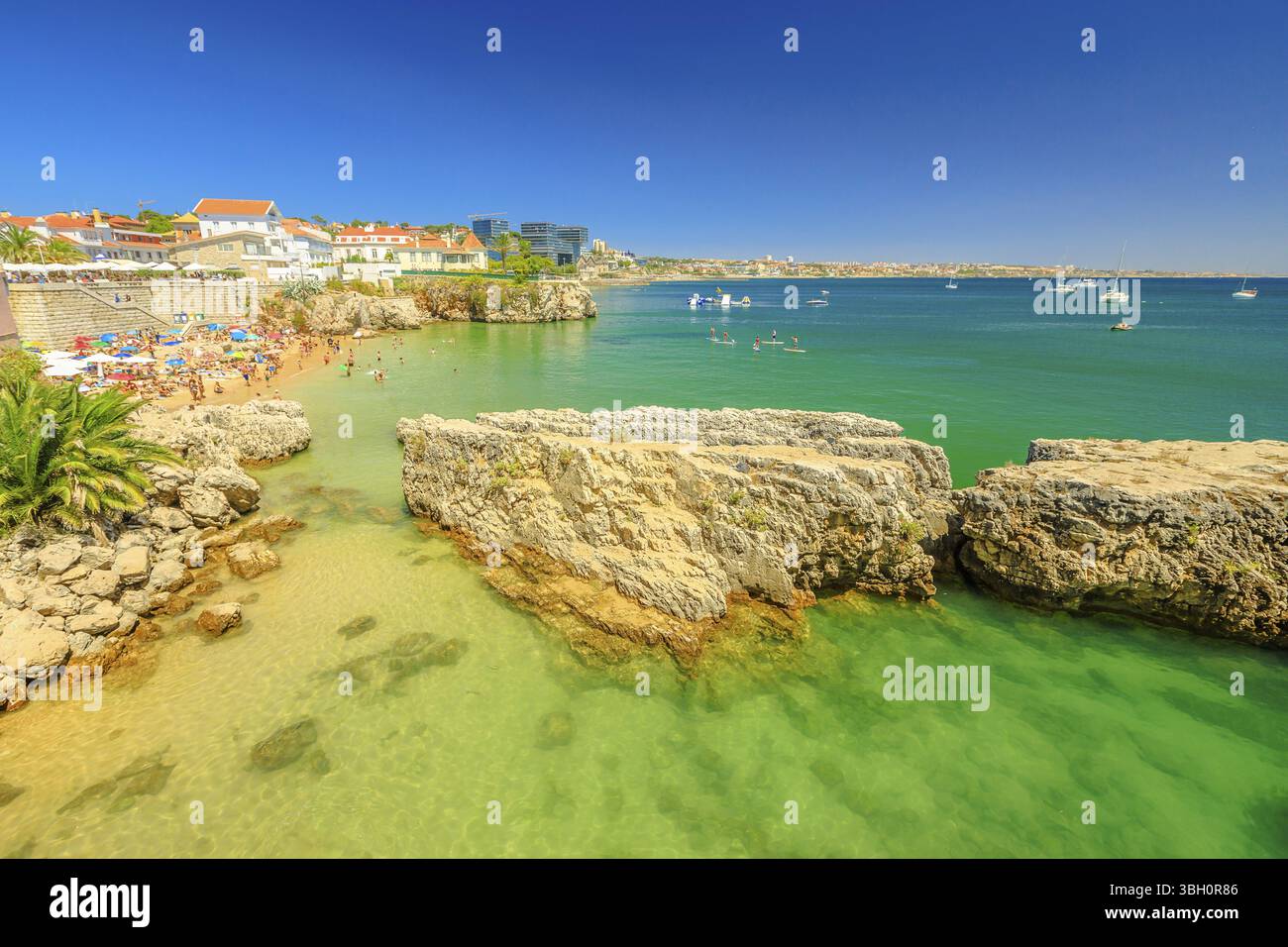 Paesaggio panoramico di Praia da Rainha, piccola spiaggia con scogliere nel centro di Cascais, Portogallo. Vista aerea della costa di Lisbona. Persone che prendono il sole e nuotano Foto Stock