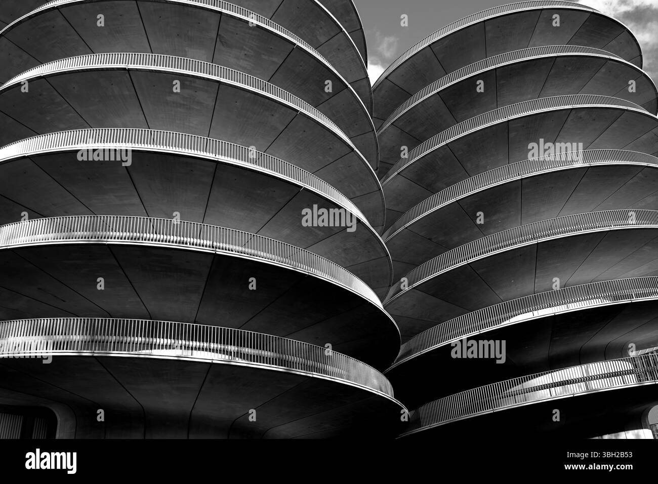 Foto architettonica in bianco e nero del parcheggio a spirale di Benthem Crouwel ad Amsterdam, che mette in evidenza curve geometriche e trame in cemento. Foto Stock