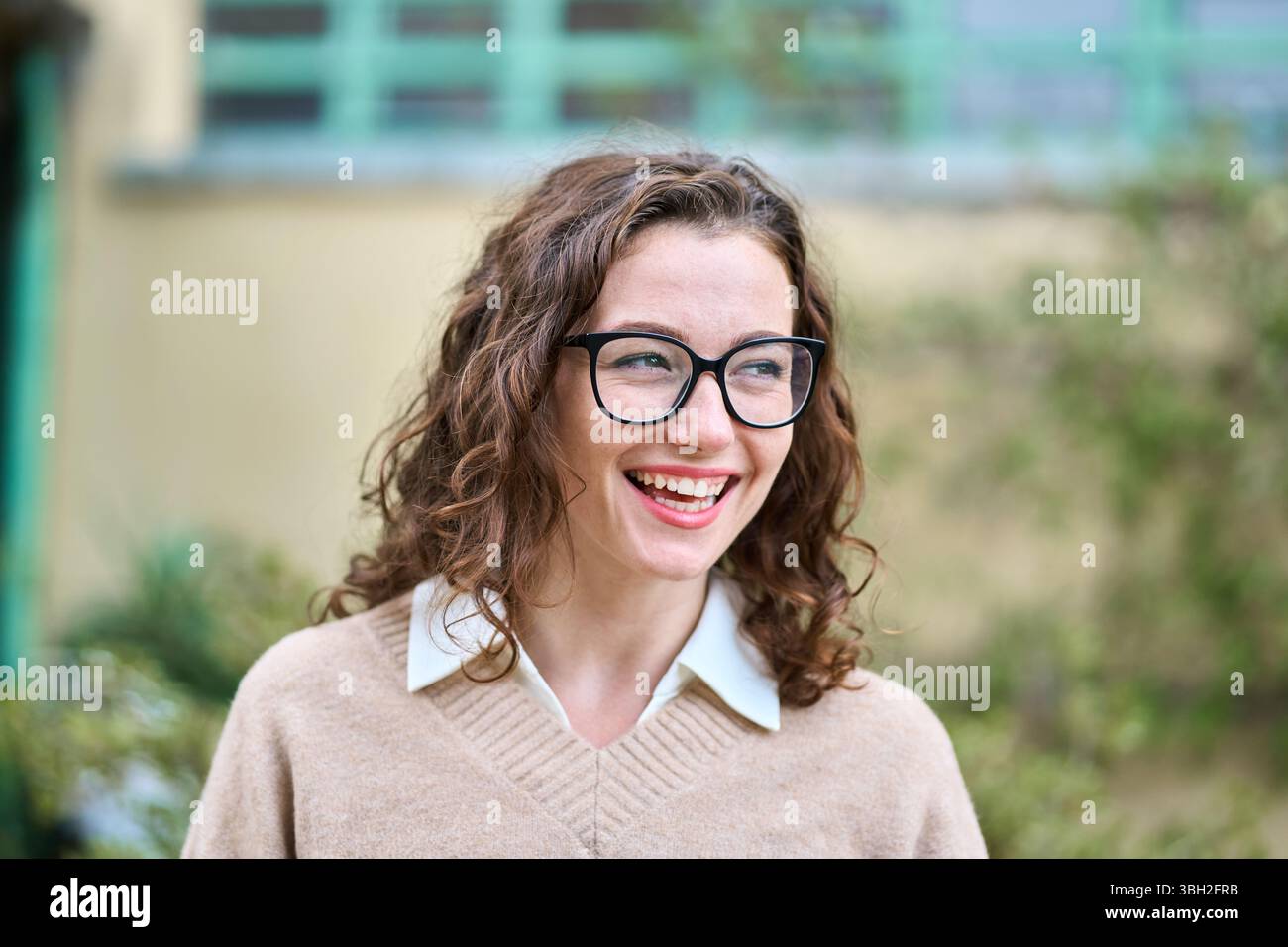 Giovane donna d'affari professionale sorridente in piedi all'aperto, ritratto. Foto Stock