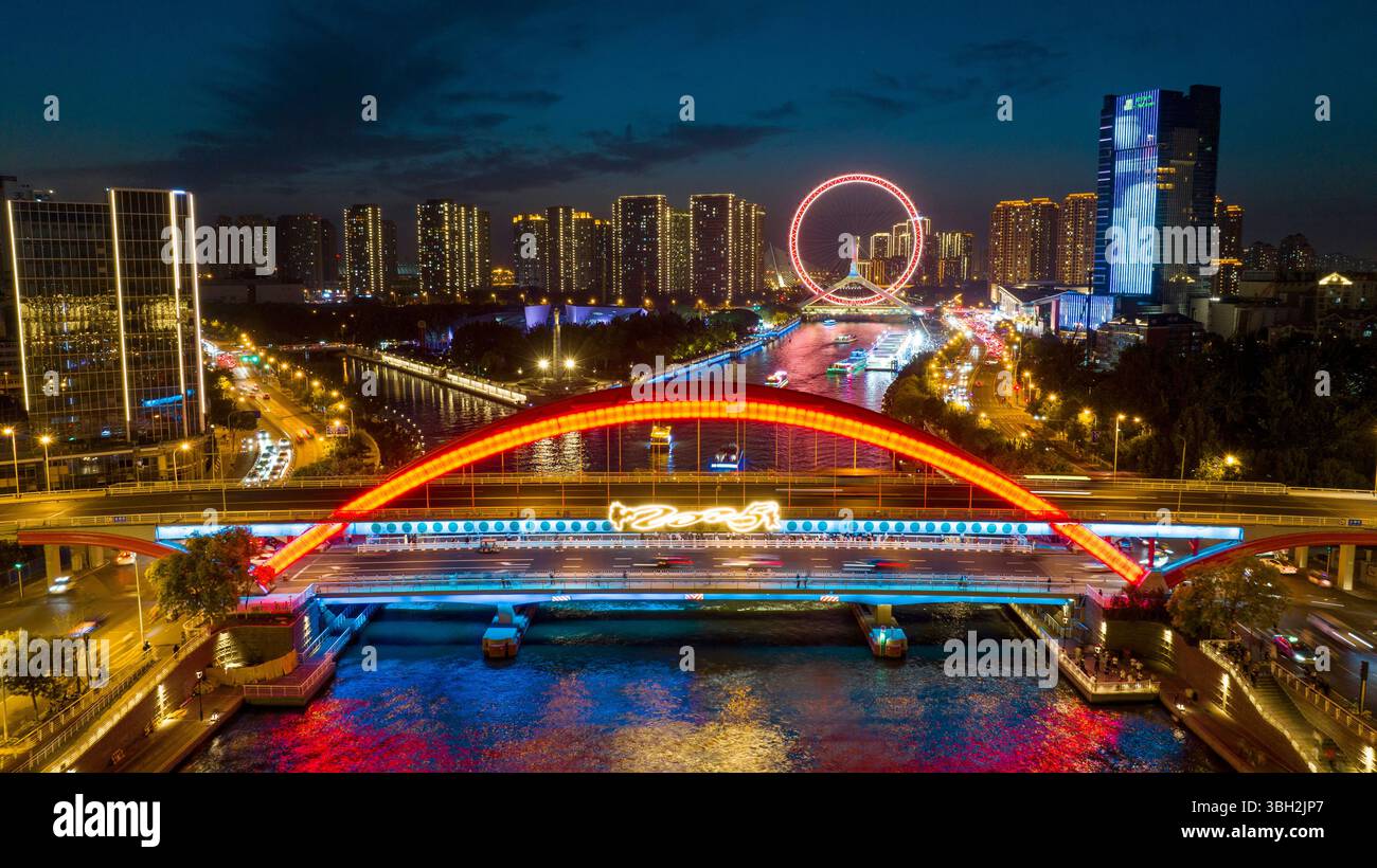 Tianjin. 6 giugno 2025. Una foto scattata con un drone il 6 giugno 2025 mostra una vista notturna lungo il fiume Haihe, a Tianjin nella Cina settentrionale. Tianjin ha migliorato le strutture di illuminazione di 216 edifici, 13 ponti, 8,2 chilometri di sponde del fiume e 7 moli lungo il fiume Haihe dall'inizio di quest'anno. L'illuminazione del paesaggio lungo il fiume è stata notevolmente migliorata, delineando una distintiva vista notturna della città. Crediti: Zhao Zishuo/Xinhua/Alamy Live News Foto Stock