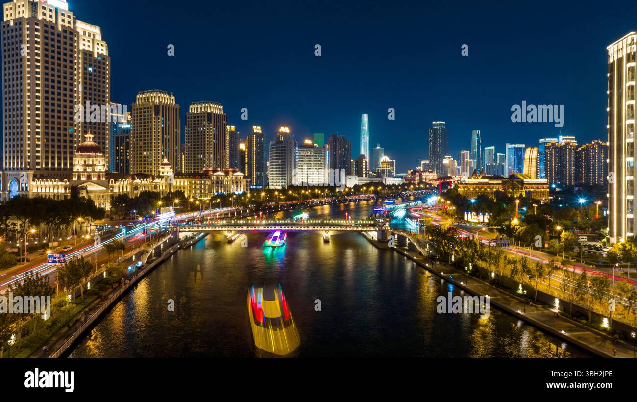 Tianjin. 6 giugno 2025. Una foto scattata con un drone il 6 giugno 2025 mostra le navi da crociera che navigano sul fiume Haihe, a Tianjin, nella Cina settentrionale. Tianjin ha migliorato le strutture di illuminazione di 216 edifici, 13 ponti, 8,2 chilometri di sponde del fiume e 7 moli lungo il fiume Haihe dall'inizio di quest'anno. L'illuminazione del paesaggio lungo il fiume è stata notevolmente migliorata, delineando una distintiva vista notturna della città. Crediti: Zhao Zishuo/Xinhua/Alamy Live News Foto Stock