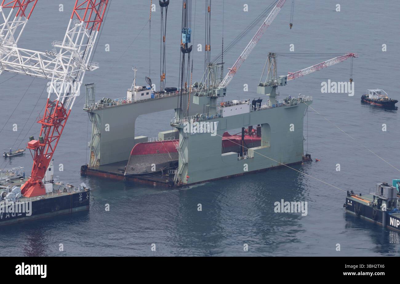 An aerial photo shows the Japanese Maritimes Self-Defense Force minesweeper Ukushima pulled out of the sea and placed in a floating dock, in Munakata City, Fukushima Prefecture, Japan on June 7, 2025. The minesweeper Ukushima caught fire and sank off the coast of Fukuoka Prefecture in November last year while sailing. ( The Yomiuri Shimbun via AP Images ) Foto Stock