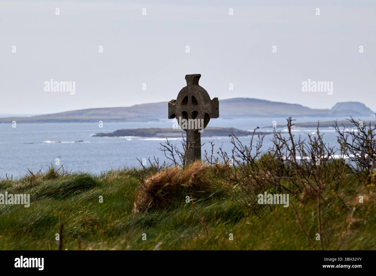 croce celtica nel cimitero che si affaccia sul mare presso la chiesa di st deirbhile dervlas nella contea di fallmore mayo repubblica d'irlanda Foto Stock