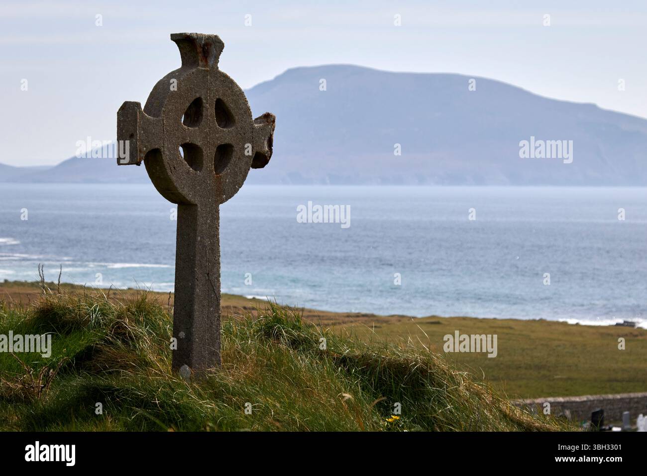 croce celtica nel cimitero che si affaccia sul mare presso la chiesa di st deirbhile dervlas nella contea di fallmore mayo repubblica d'irlanda Foto Stock