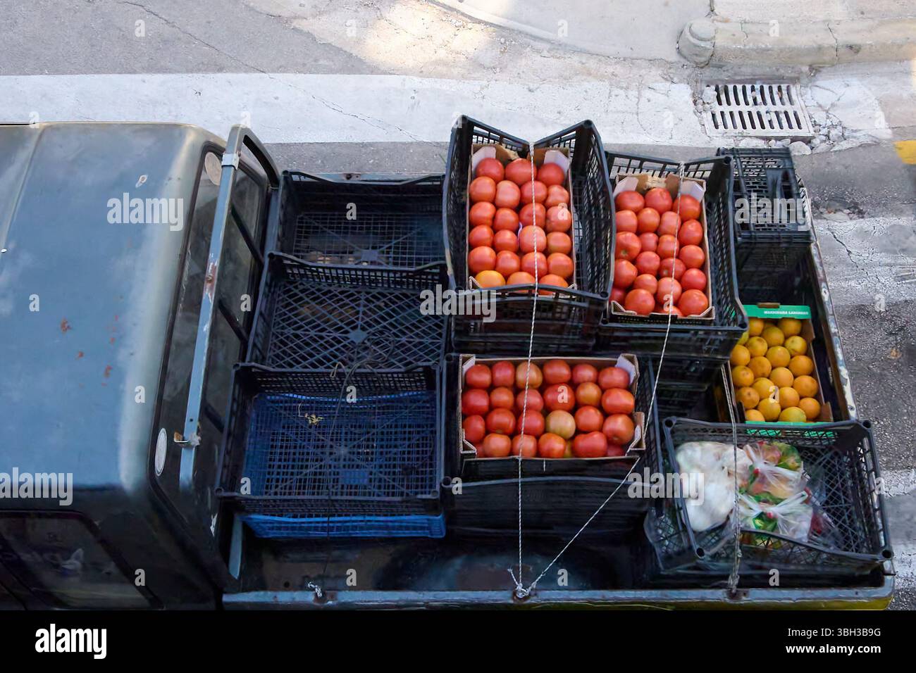 Vista dall'alto del retro di un camion carico di casse di pomodori maturi, agrumi e altri prodotti freschi Foto Stock