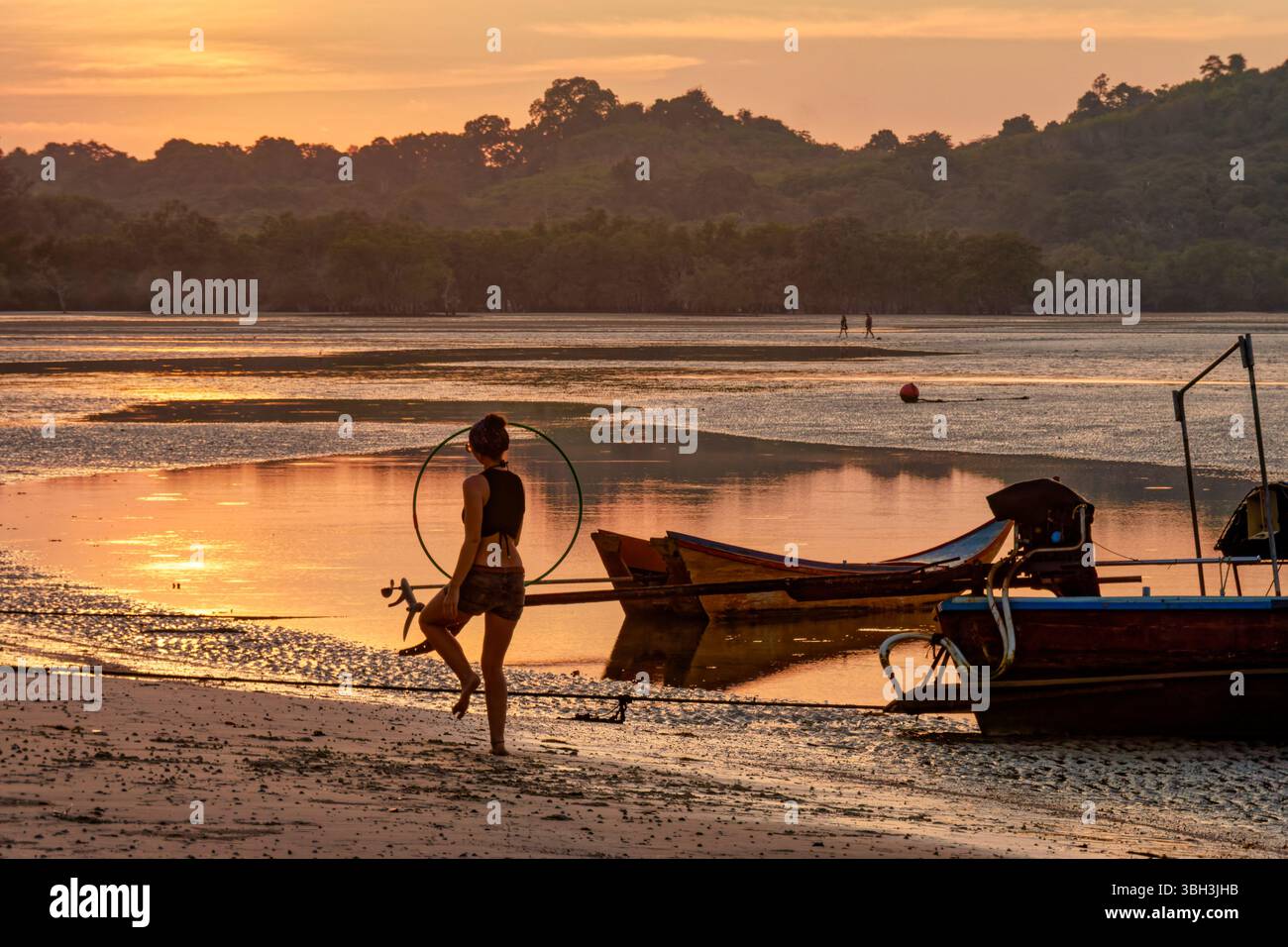 Sonnenuntergang , Buffallo Bay , Koh Phayam, ebbe, Frau mit Reifen, Thailandia , Asien Foto Stock