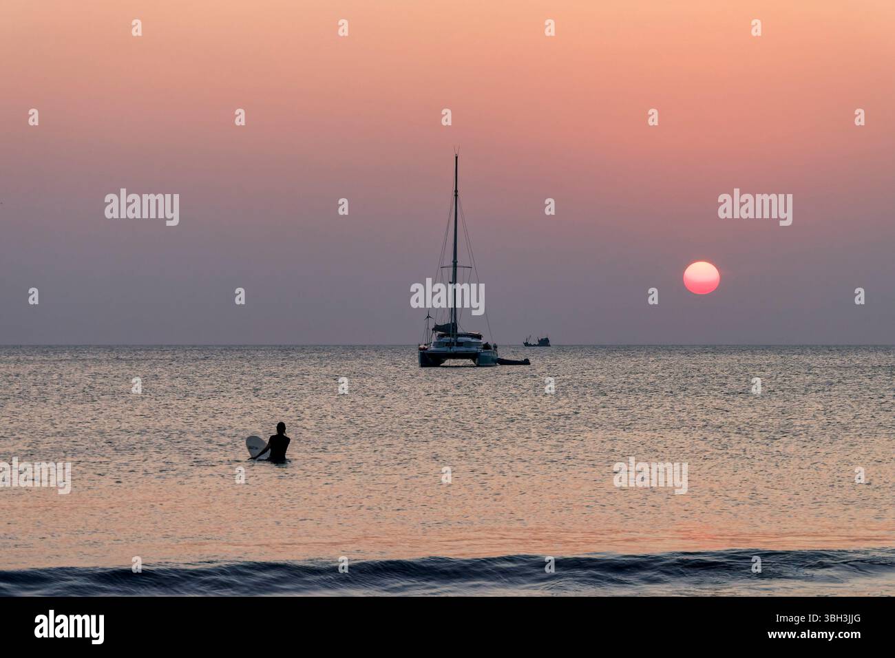 Sonnenuntergang am Long Beach a Koh Phayam, Surfer, Katamaran, Thailandia | tramonto a Long Beach, Ao Yai, surfista, catamarano, Koh Phayam, Thailandia Foto Stock