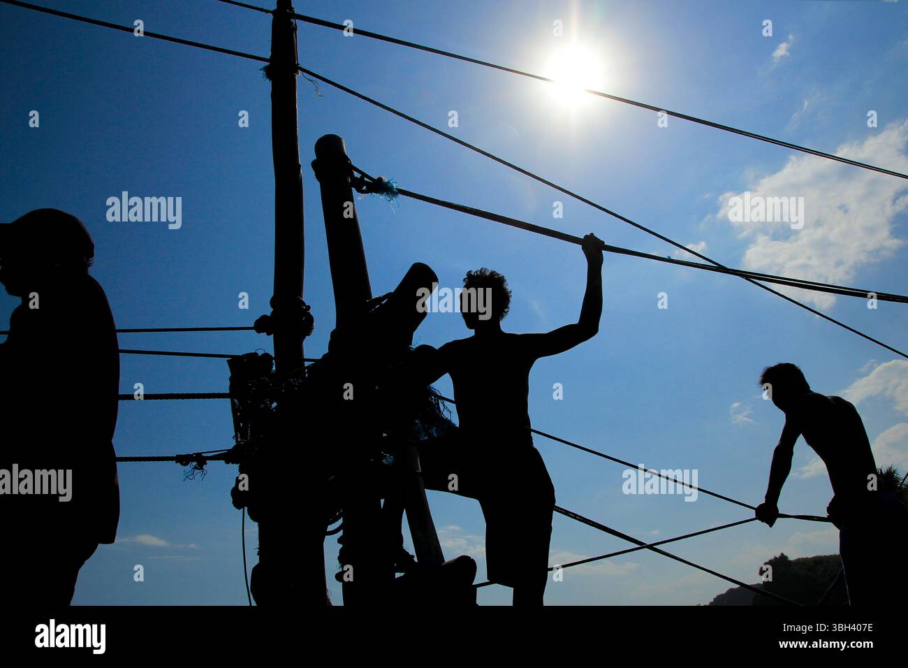 Sagoma dei lavoratori che gestiscono il trasporto in funivia tradizionalmente utilizzando semplici attrezzature di funi e fili. Foto Stock