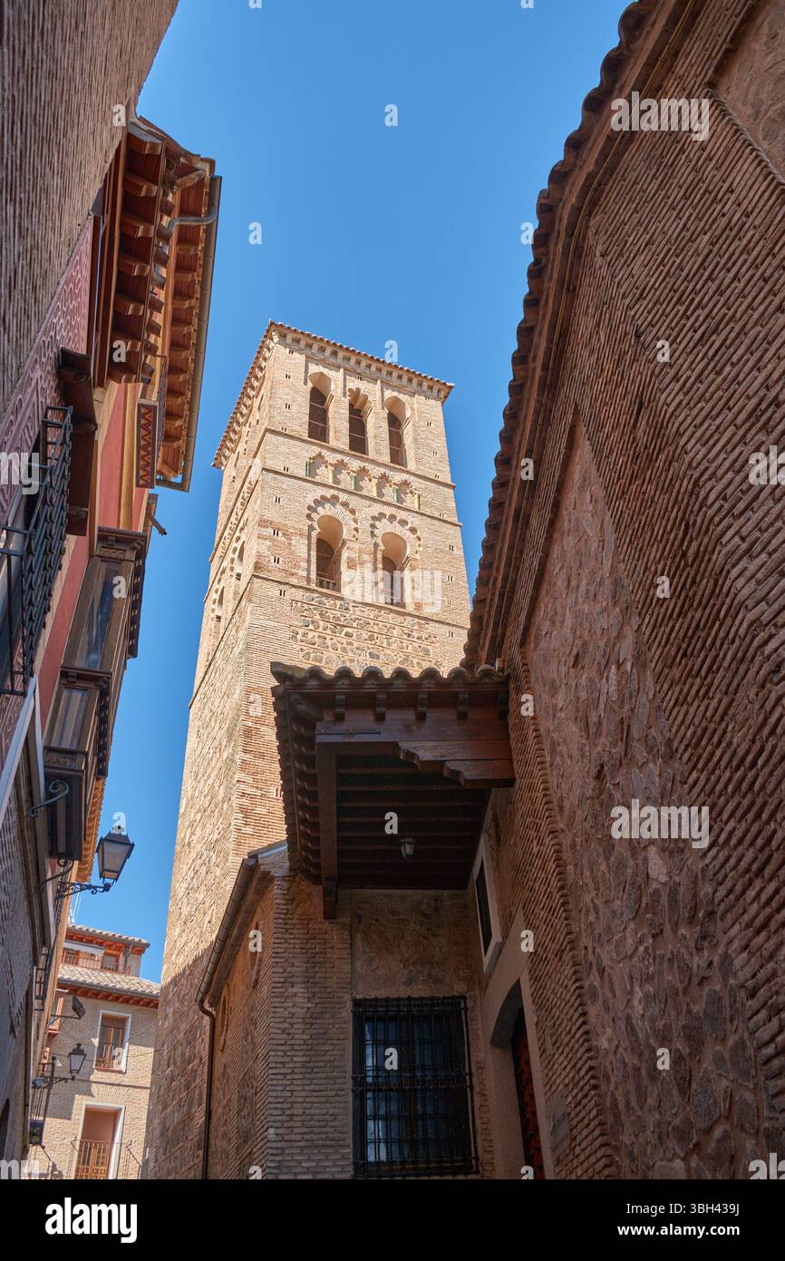 Il campanile in stile mudejar della chiesa di Santo Tomé si erge alto contro un cielo azzurro limpido, caratterizzato da intricati mattoni e motivi geometrici tipici Foto Stock