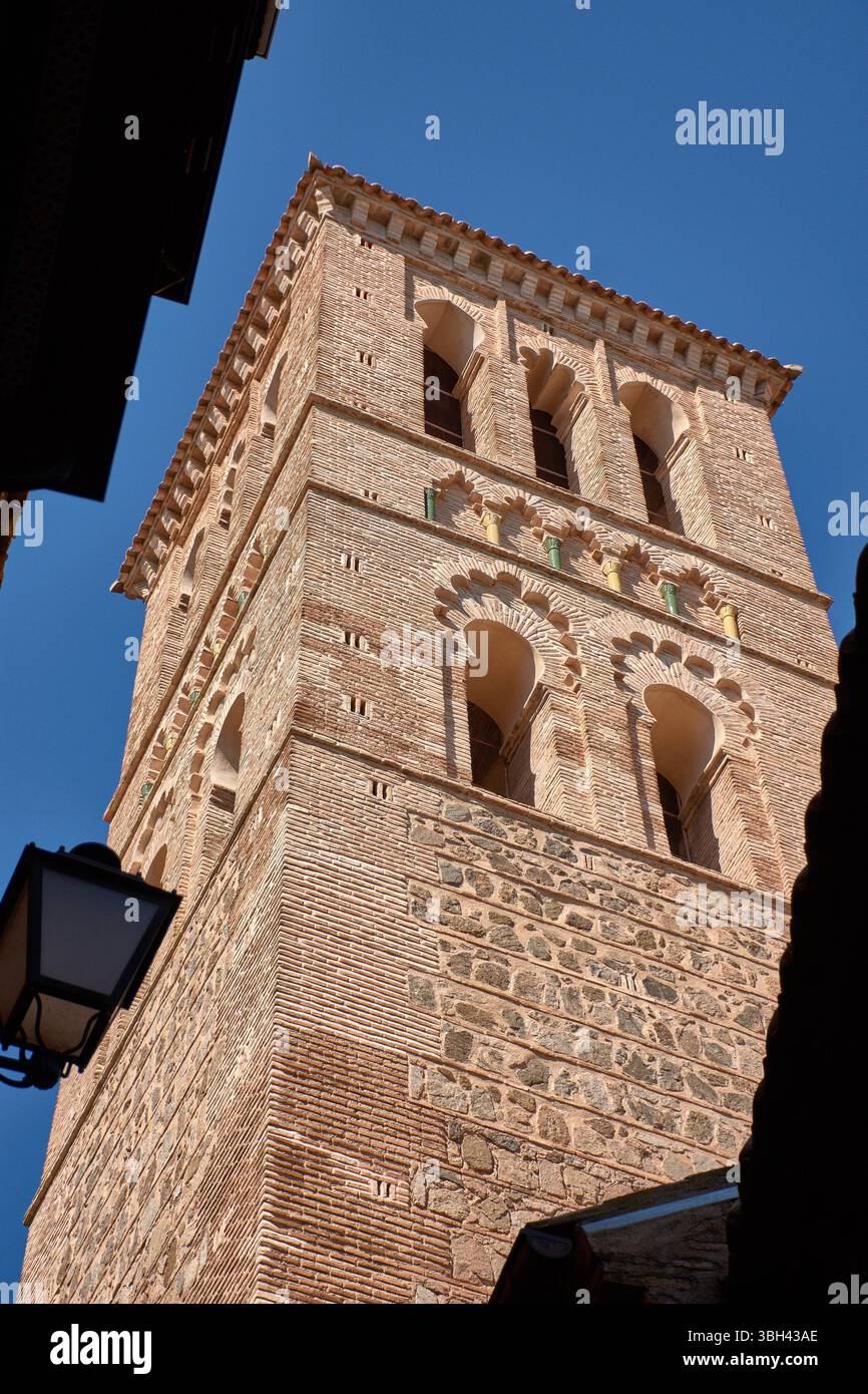 Il campanile in stile mudejar della chiesa di Santo Tomé si erge alto contro un cielo azzurro limpido, caratterizzato da intricati mattoni e motivi geometrici tipici Foto Stock