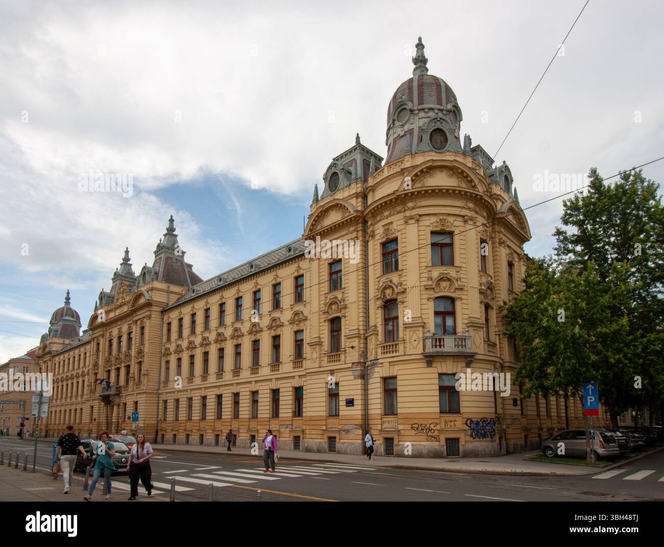 ZAGABRIA, CROAZIA - 22 MAGGIO 2025: Un grande e ornato edificio giallo, caratteristico dell'architettura storica europea Foto Stock