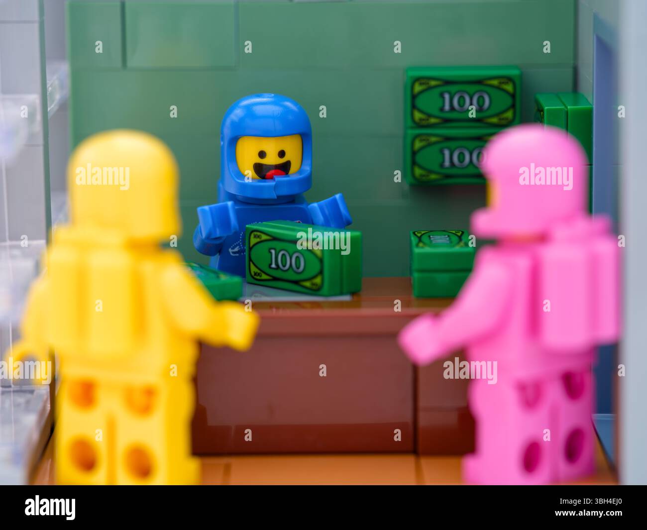 Tambov, Federazione Russa - 26 maggio 2025 tre astronauti Lego minifigure in piedi vicino a un tavolo con soldi in carica Foto Stock