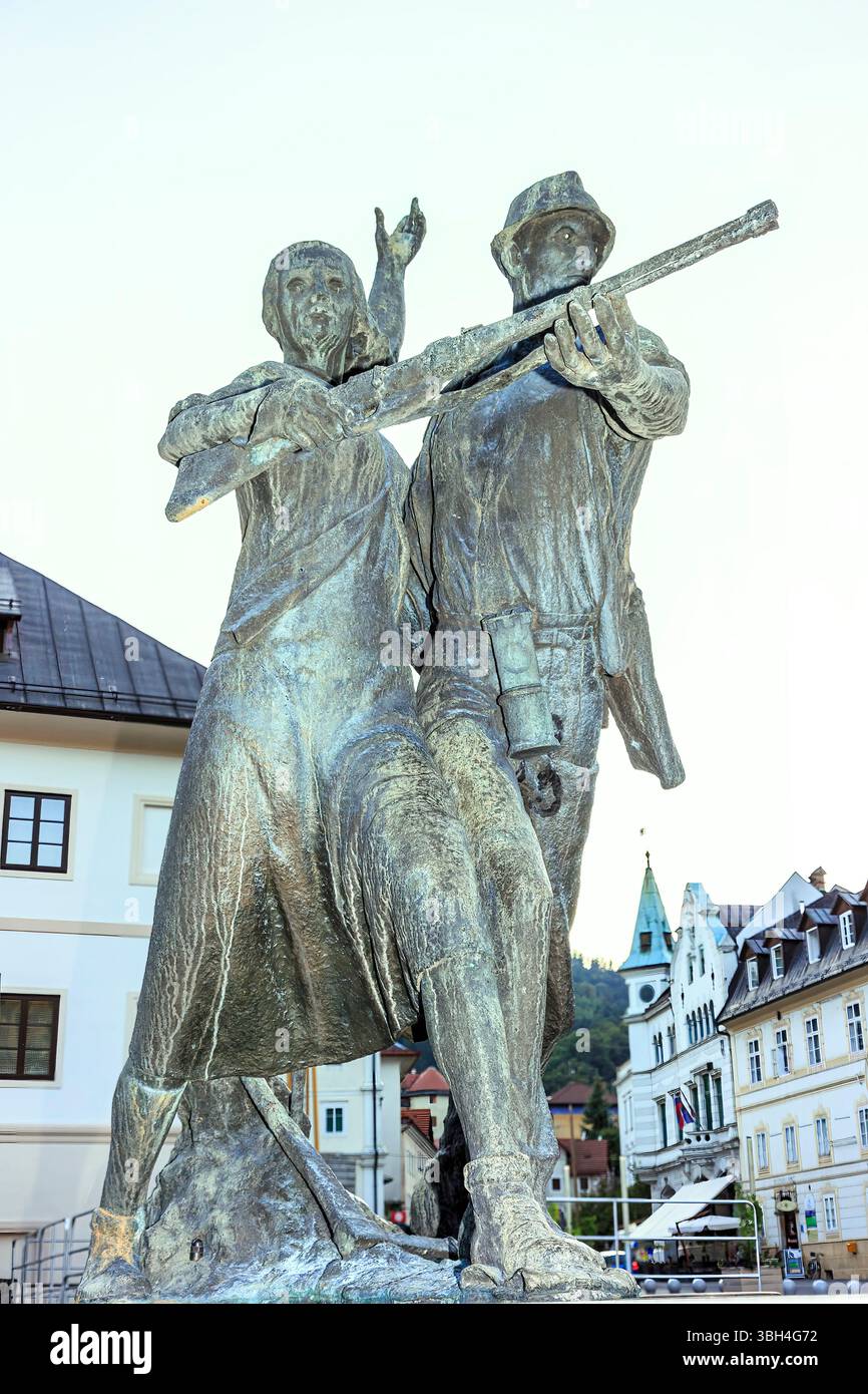 Monumento all'Esercito di Liberazione Nazionale, a Mestni trg di uomo e donna con fucile, piazza della città, Idrija, Slovenia Foto Stock