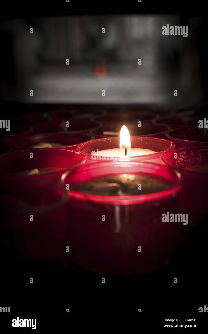 Gruppo di candele rosse in una chiesa Foto Stock
