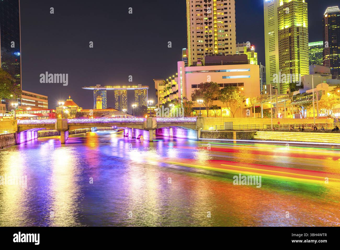 Il Clarke Quay bridge e area di Riverside in notturna a Singapore, Sud-est asiatico. Waterfront skyline riflessa sul Fiume Singapore. Attrazione per n Foto Stock
