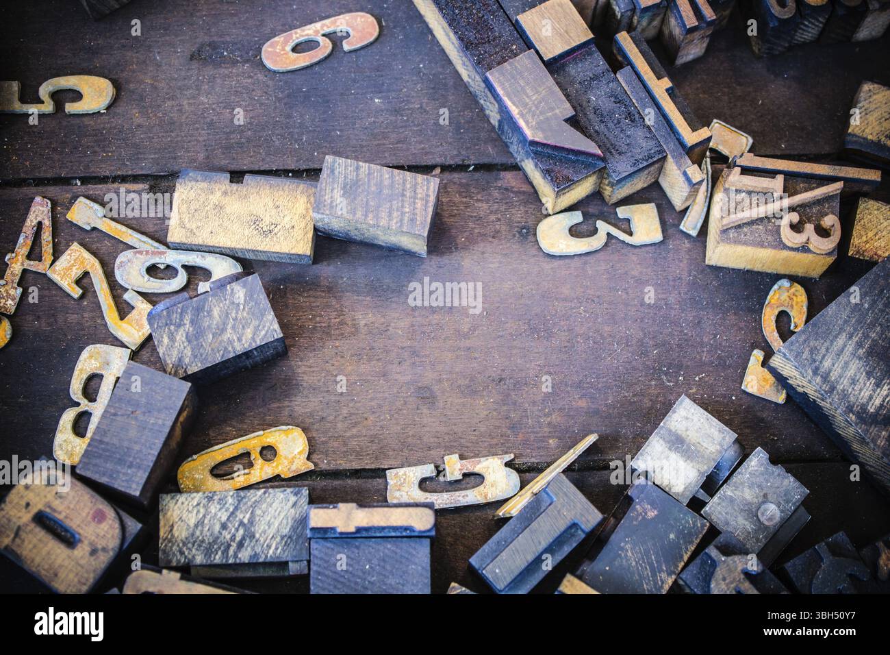 Un mucchio di lettere vintage in legno e metallo numeri, lettere e simboli su un vassoio di legno sporco Spazio per una copia Foto Stock